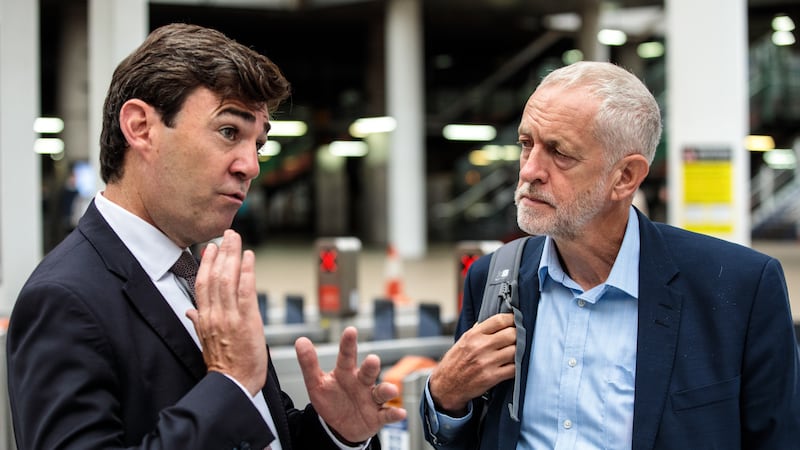 Labour leader Jeremy Corbyn is greeted by Mr Burnham as he arrives at Manchester Victoria Station in 2018