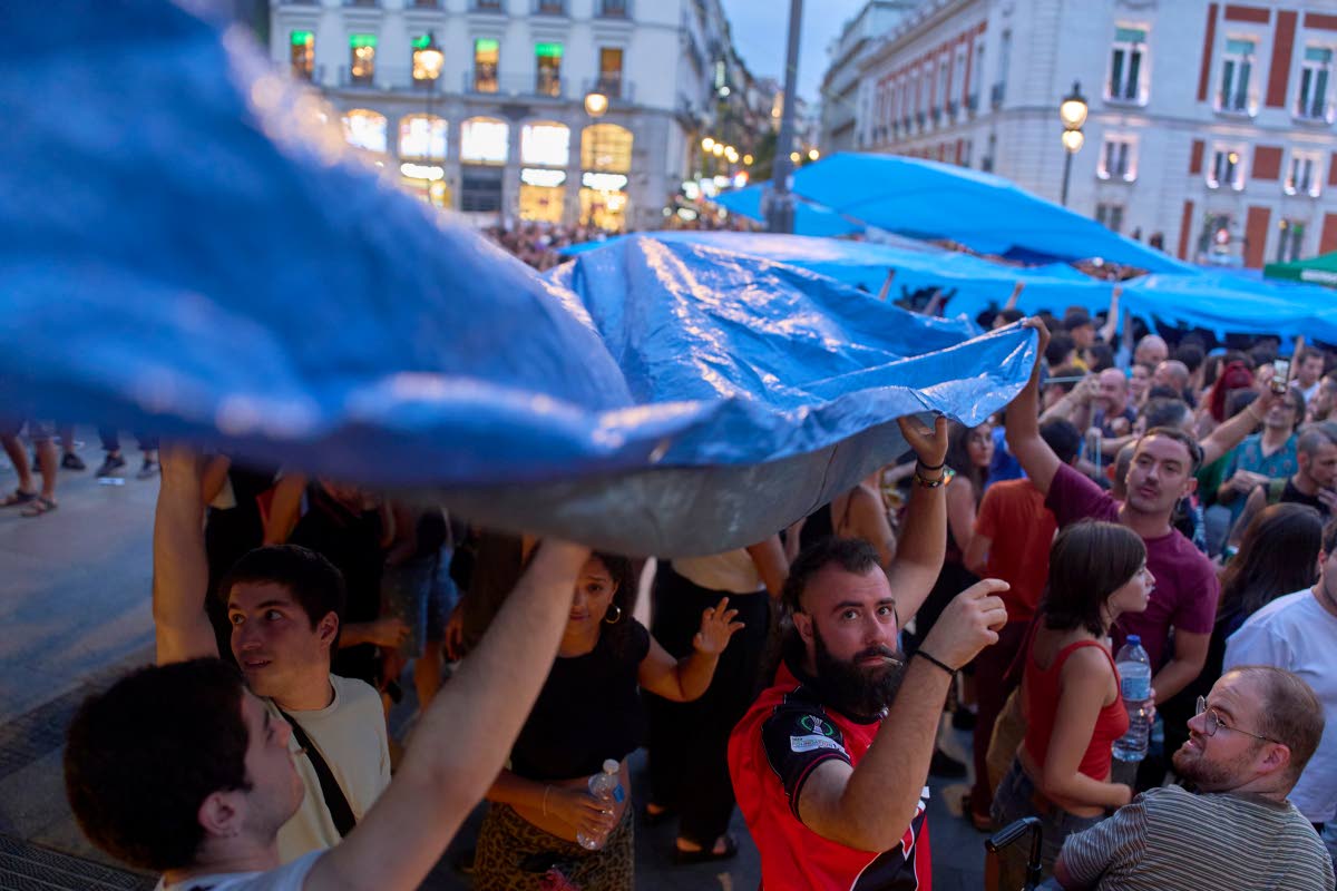 Protesters camp during a protest following the eviction last Wednesday of 87-year-old Maricarmen to demand stronger laws to protect renters, at Sol square in Madrid, Spain, Sunday.
