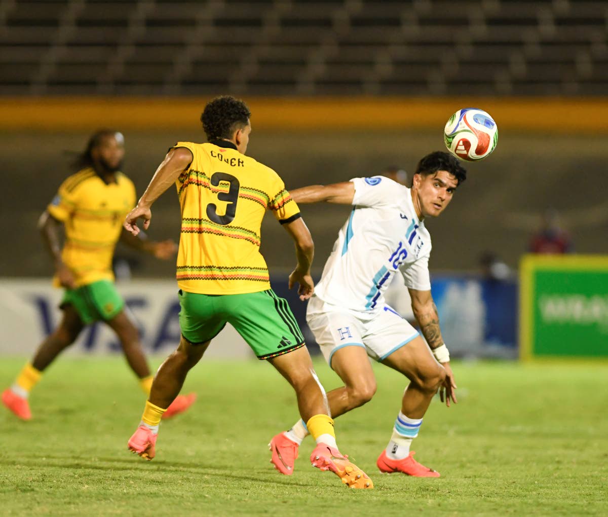 Reggae Boy defender Brandon Cover tries to get the ball away from Honduras’ Luis Palma during their Concacaf Nations League fixture at the National Stadium on Monday night.