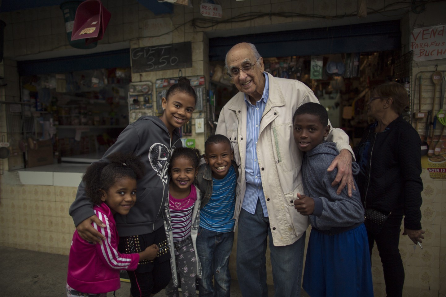 Criancas pedem para serem fotografadas com Zuenir Ventura. Zuenir Ventura, autor do livro Cidade Partida, revisita o local da chacina narrada na obra, em Vigario Geral. Ele reencontrou com familiares das vitimas e sobreviventes do massacre que matou 21 moradores — Foto: Daniel Marenco / Agencia O Globo